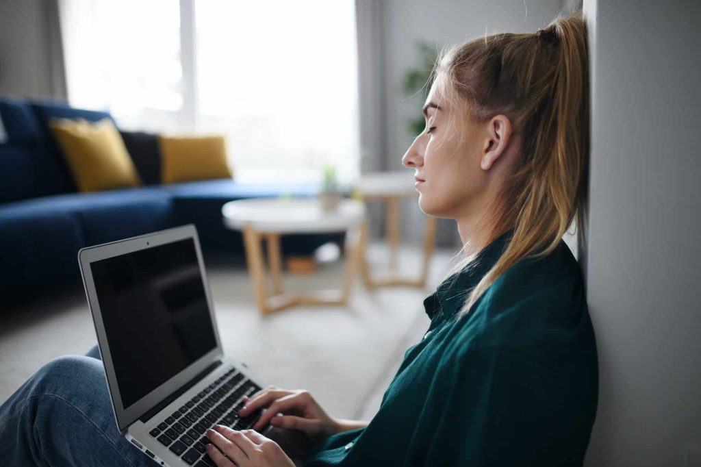 Tired young woman student with laptop at home, home office and learning