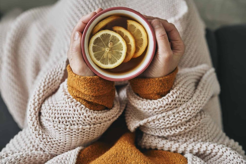 Top view of woman holding cup of hot tea