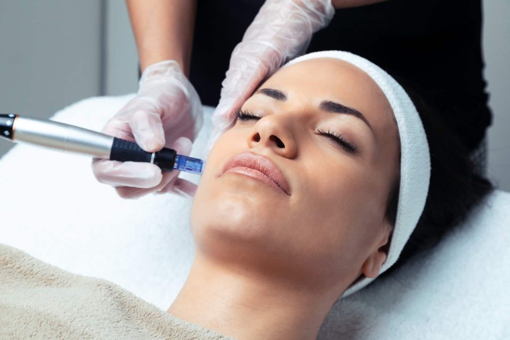 Cosmetologist making mesotherapy injection with dermapen on face for rejuvenation on the spa center.