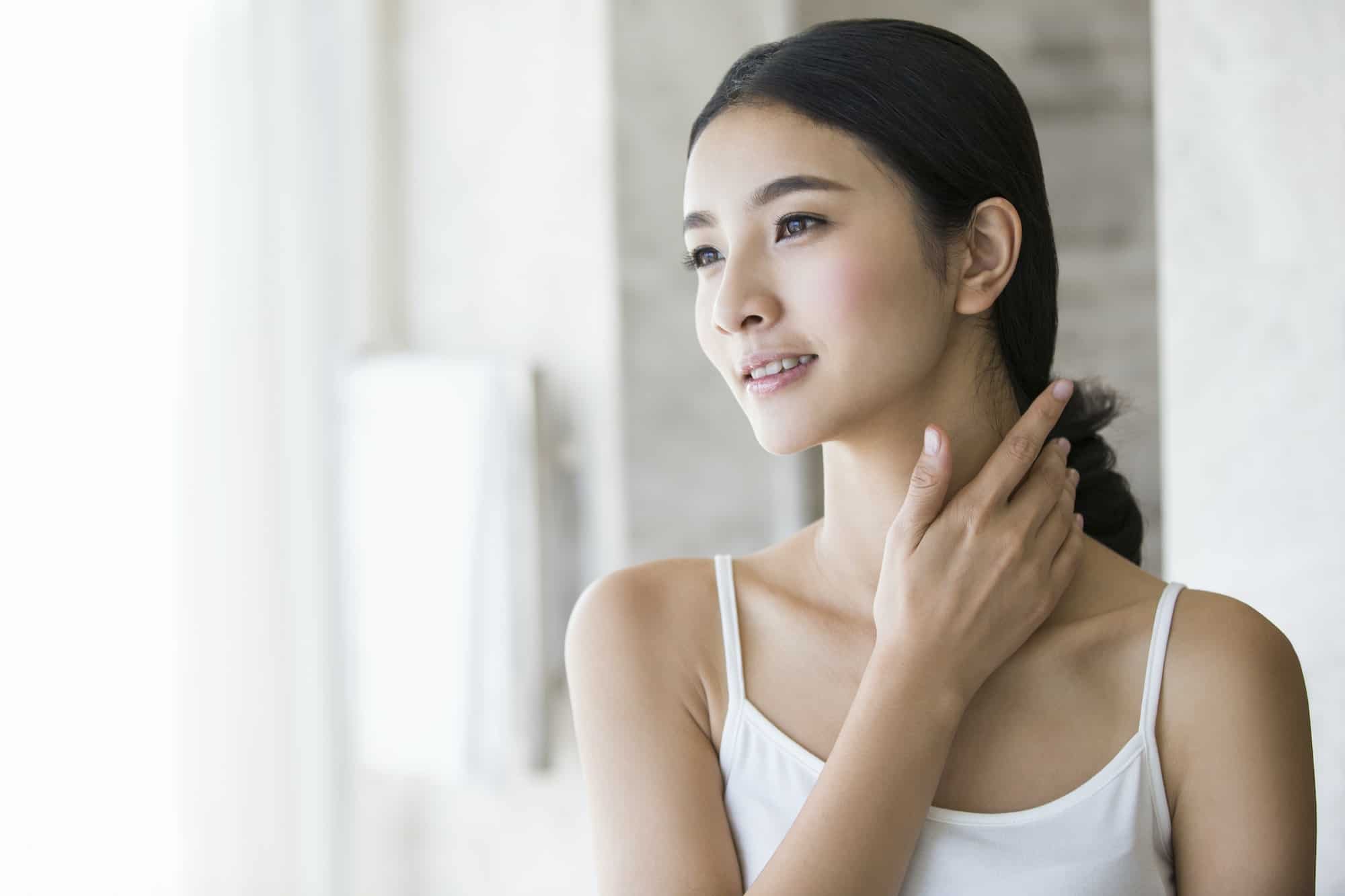 Young woman rubbing neck