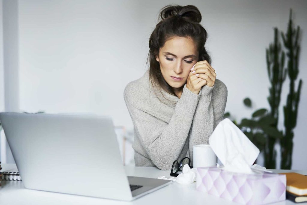 Ill woman working at home at desk
