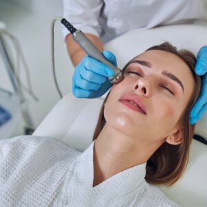 Adorable pretty lady receiving professional skin care with ultrasound device in beauty clinic