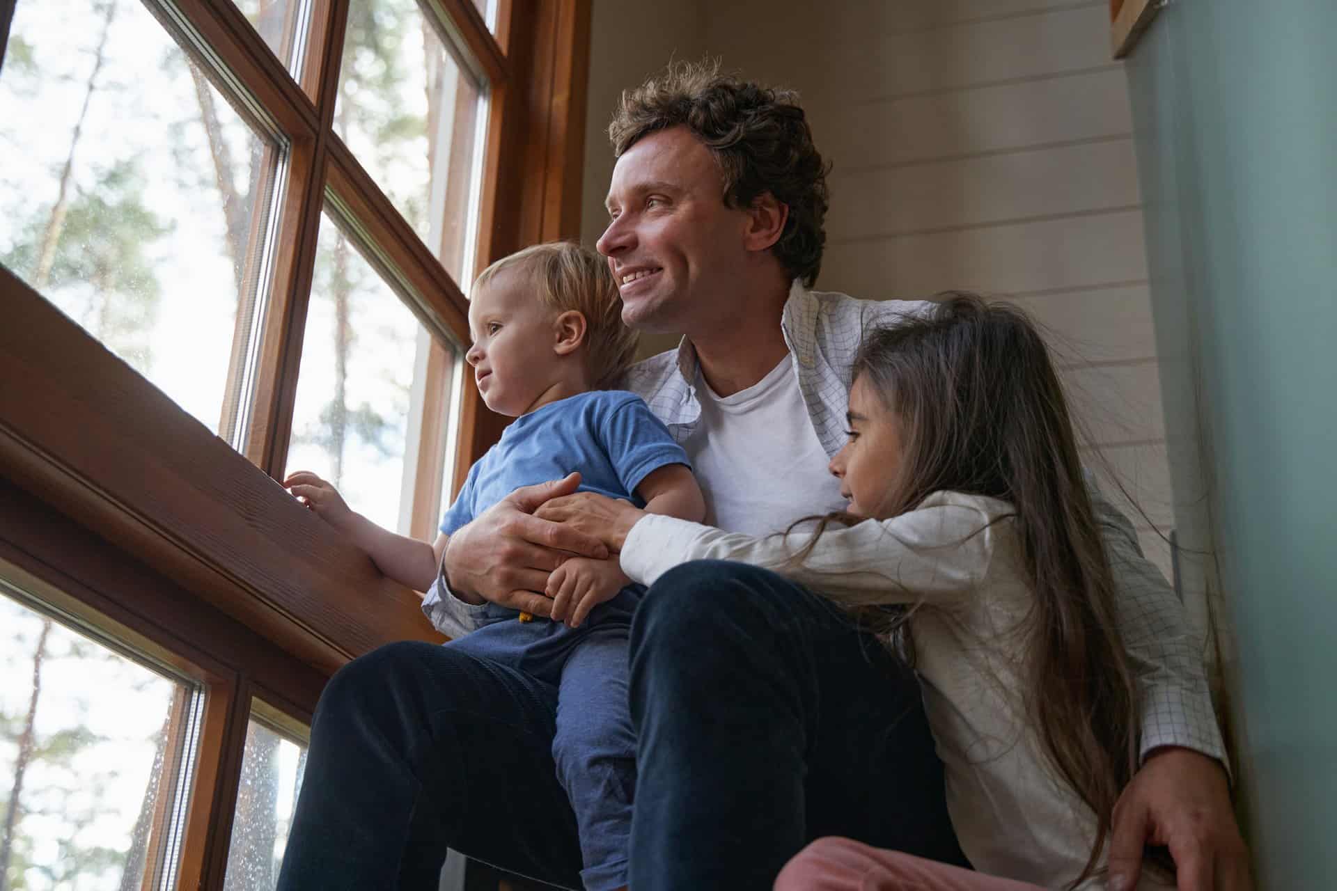 Close up of happy man embracing his children