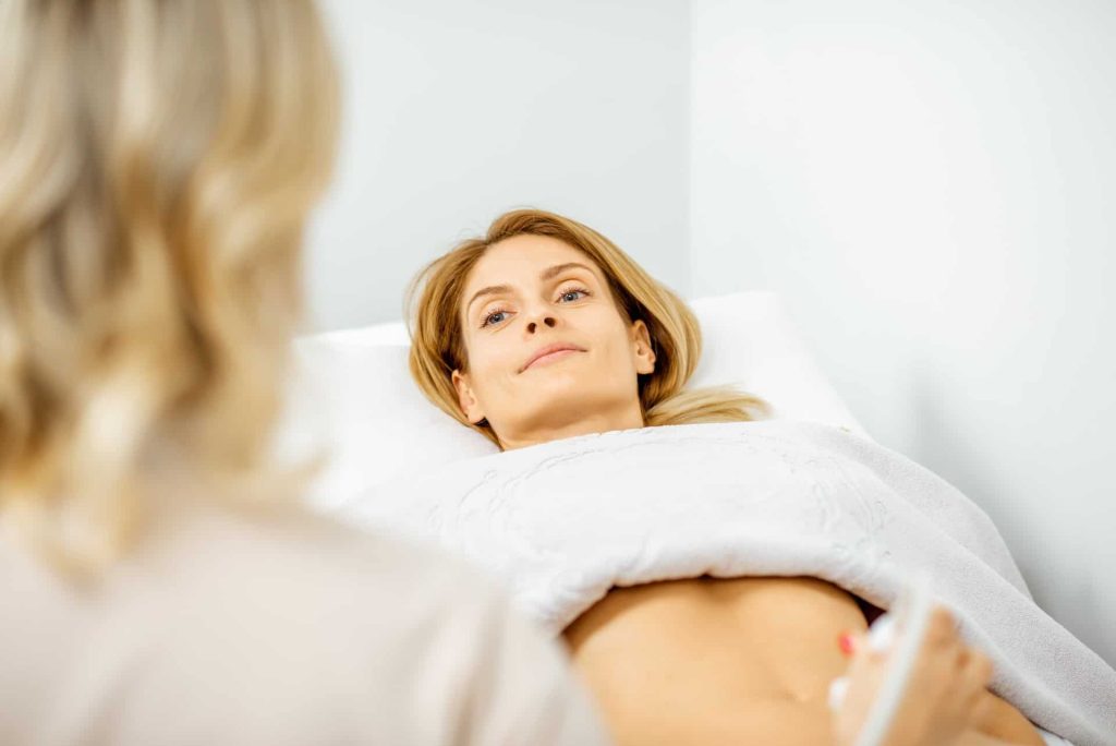 Woman examining her abdomen with ultrasound