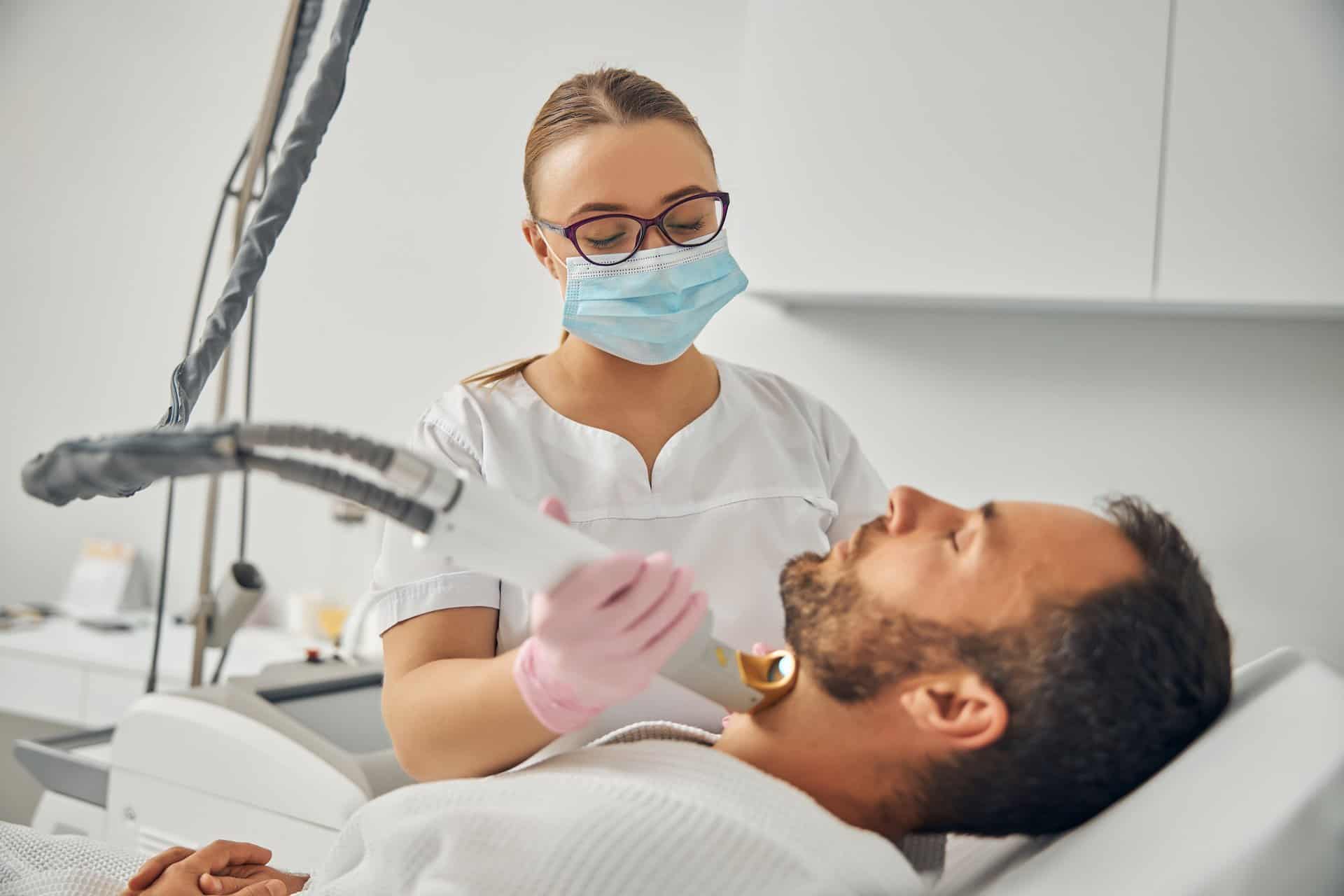 Unshaven young man undergoing laser hair removal procedure