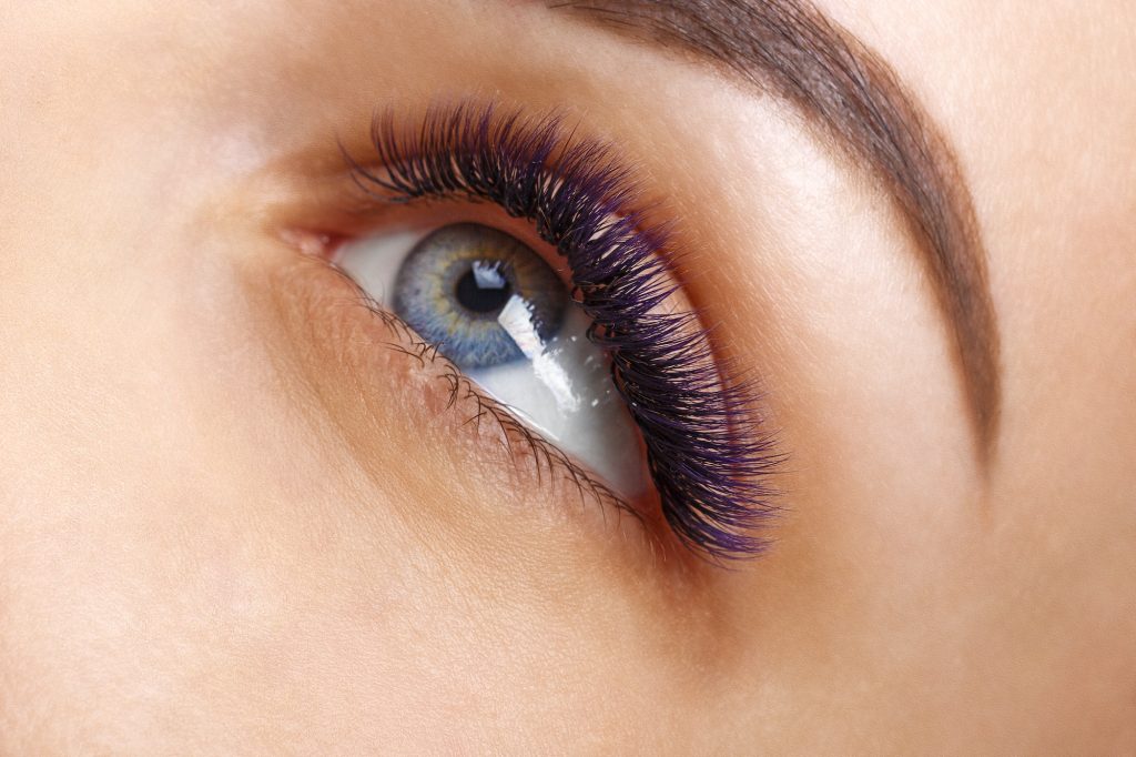 En kvinne som har fått vippeextensions. Hun har blå øyne.