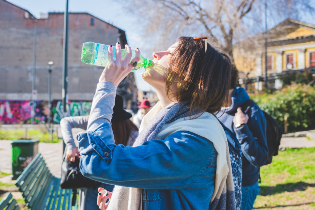 Young woman outdoor drinking water thirsty