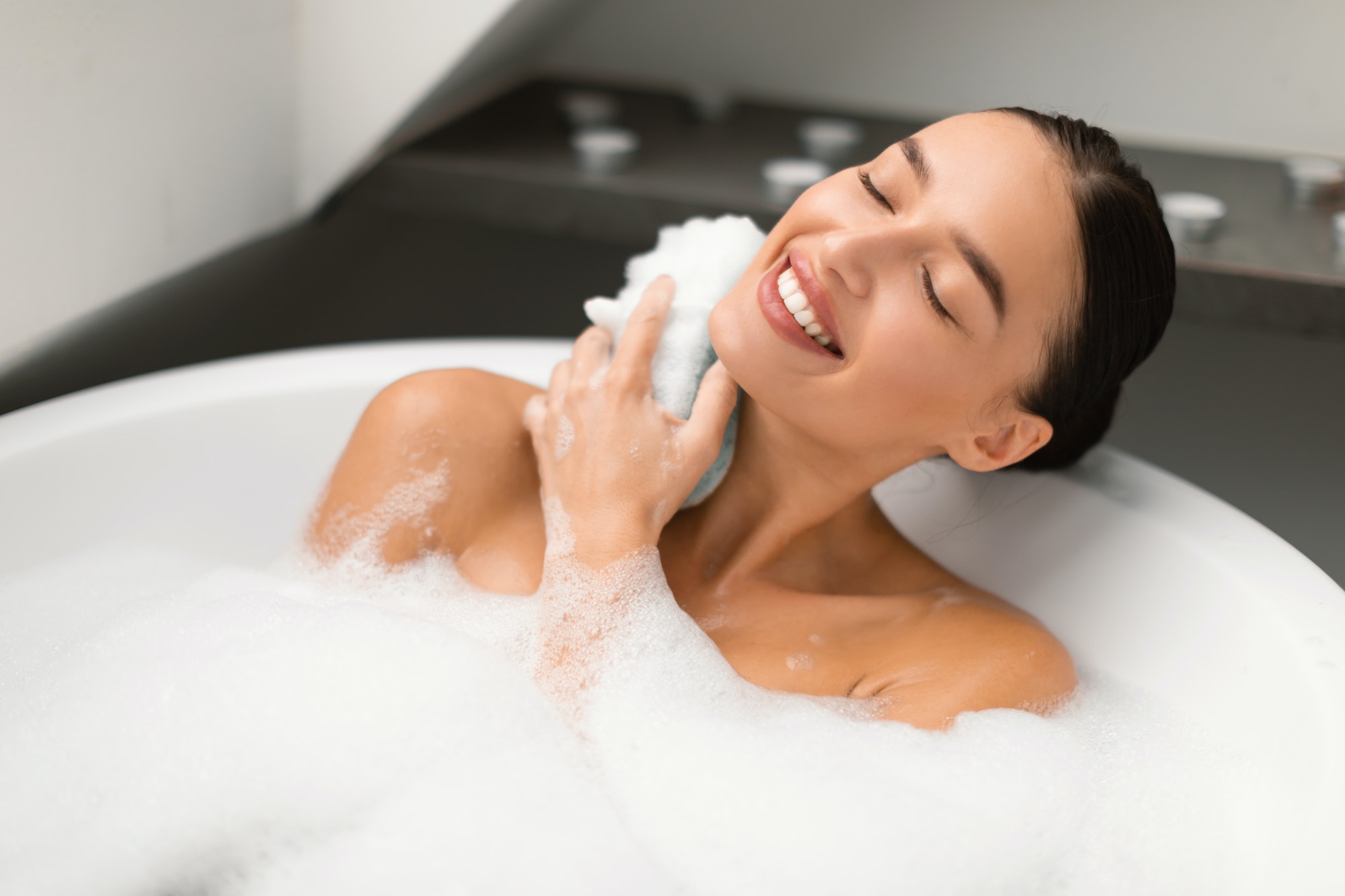 Woman Taking Bath Rubbing Neck With Sponge Bathing In Bathroom