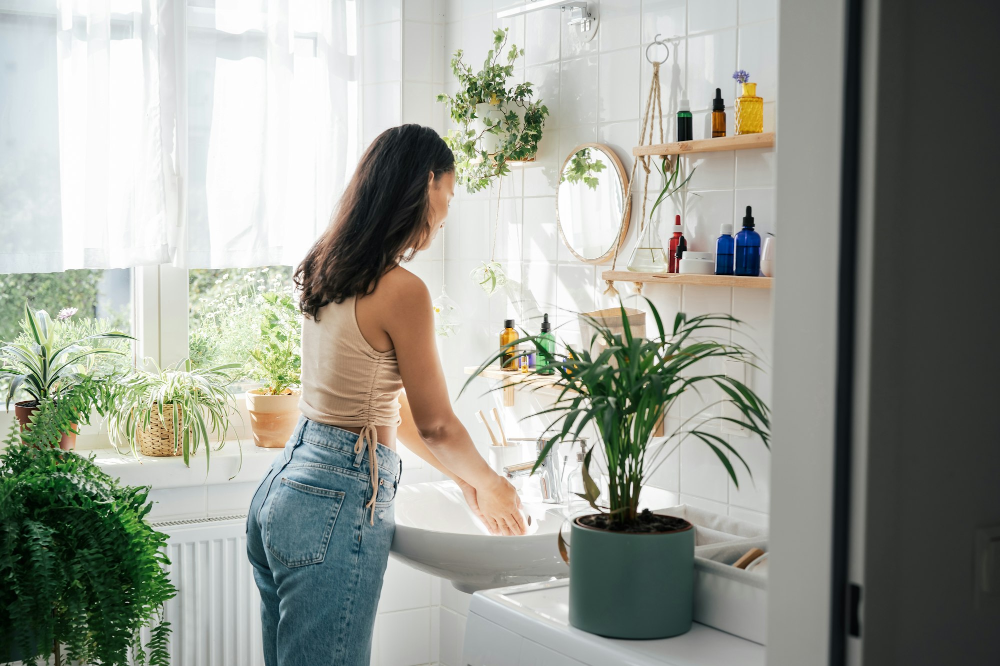 Young beautiful woman with dark skin washing hands