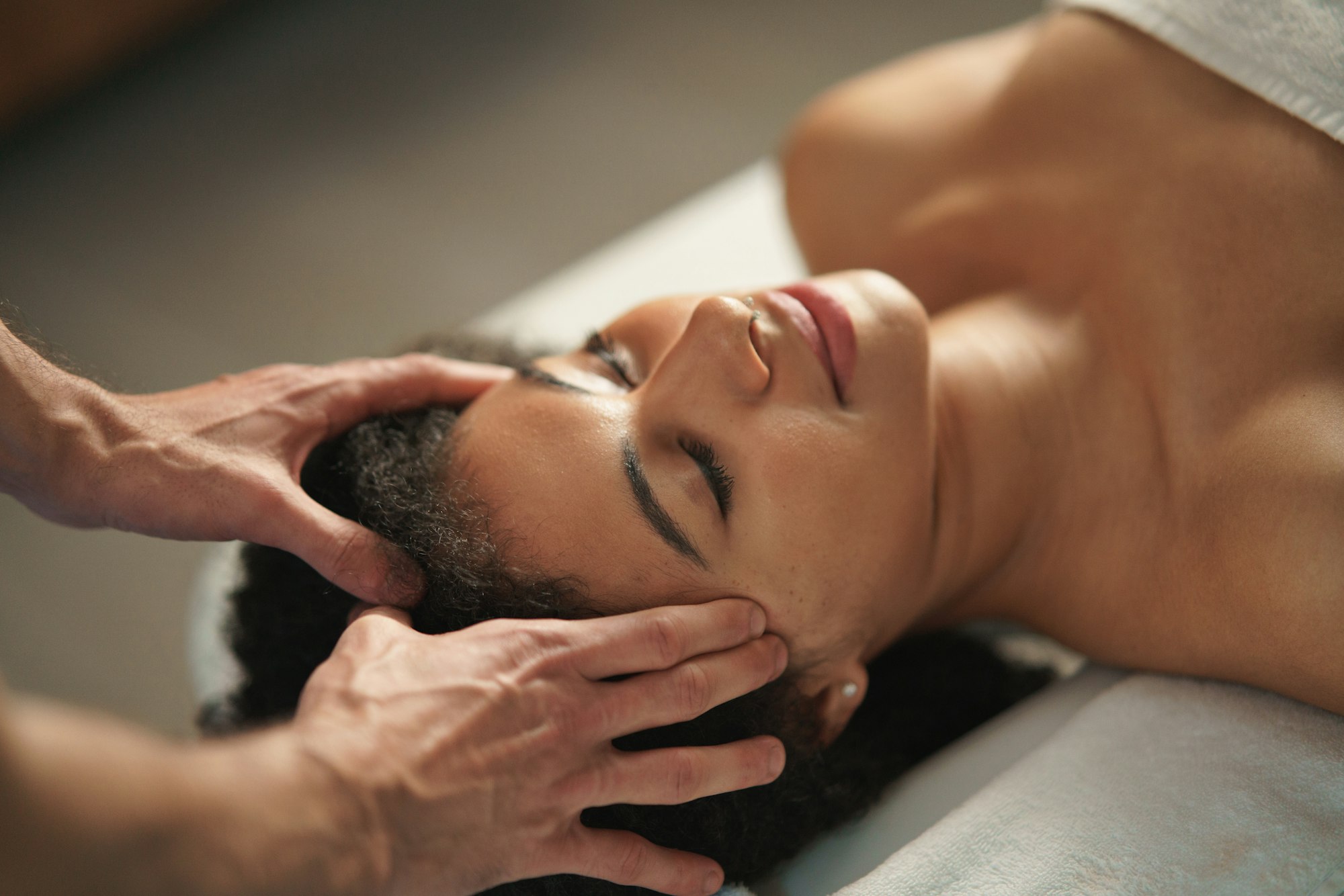 Young woman having head massage at the spa